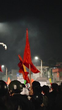 Vietnamese soccer fans celebrating victory at night waving flags
