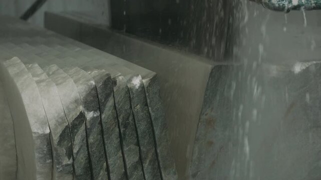 Circular saw cutting a large block of marble stone into slabs with water cooling process
