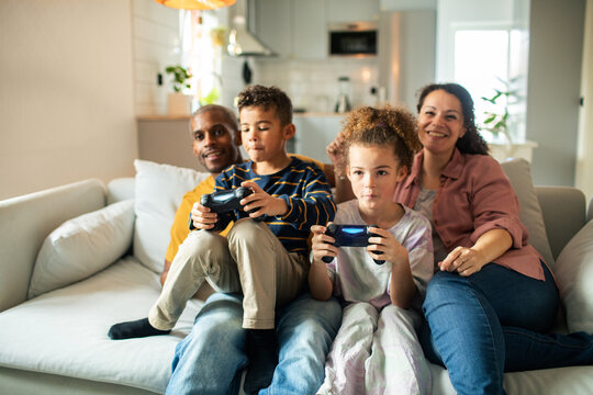 Parents and children playing video games at home