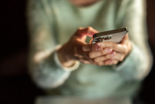 Close-up of hands texting on smartphone at home