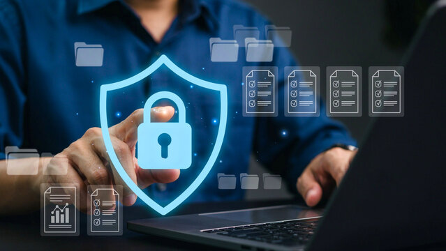 Cybersecurity Shield: A glowing digital shield with a lock icon safeguards digital files, representing data protection and online security in a technological context.