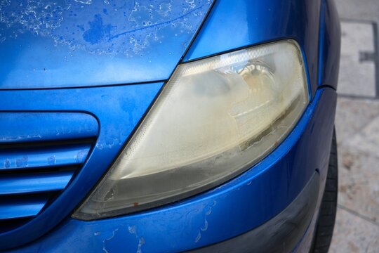 Car headlamp yellowed, fogged and hazy plastic, UV exposure damage with age. Old car problem.
