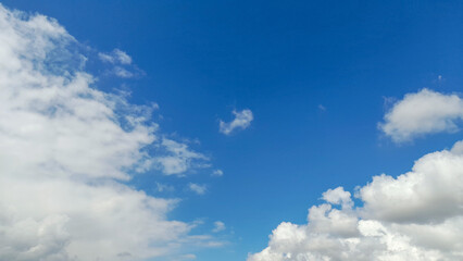 Obraz premium Beautiful white cumulus clouds on a clear blue sky background.