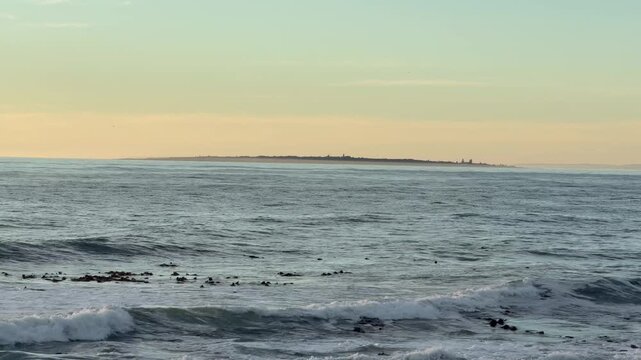Atlantic Ocean near Cape Town at dusk. Robben Island in the distance.
