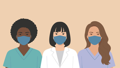 Fototapeta premium Three ethnically diverse female medical professionals wearing protective face masks and clean clinical scrubs.