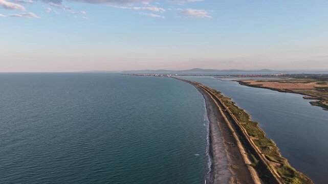 Aerial view of a narrow sand spit road separating the Black Sea from Lake Pomorie in Bulgaria