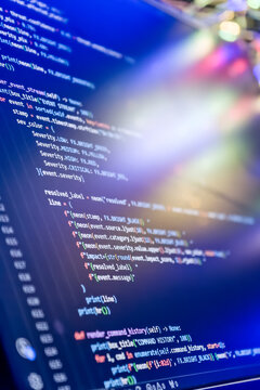 Cyberpunk style hacking code on monitor. Software development, artificial intelligence and data analysis concept with colorful light leaks.
