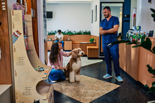 Veterinarian talking to owner with dog in clinic waiting room