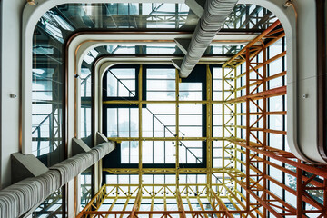 Obraz premium Modern Atrium Interior Looking Up Through Multiple Glass Floors with Industrial Skylight Design