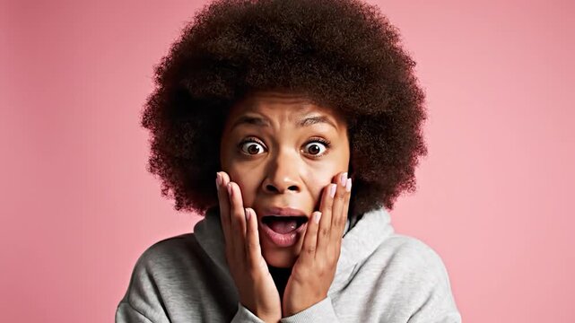 A person with an afro looks utterly shocked and surprised by something