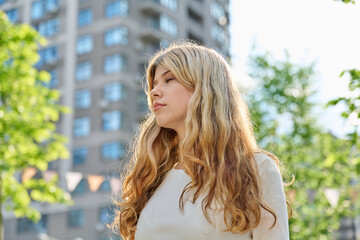 Fototapeta premium Blonde teenage girl with closed eyes in city park