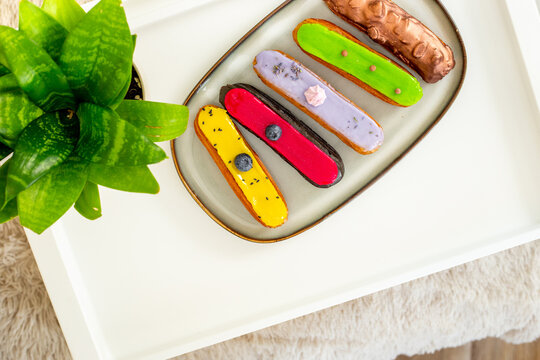 French eclairs served on plate - colorful artisan dessert composition with soft daylight, top view food photography