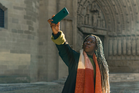 Woman traveling taking selfie video with smartphone outdoors