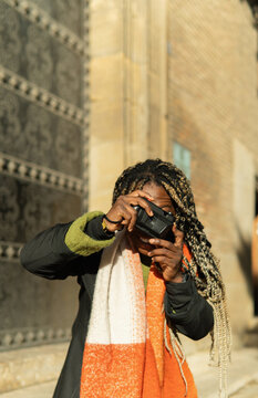 African american woman capturing city street moments with camera
