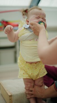 Baby exercising legs with therapist guidance during a pediatric developmental session focusing on rehabilitation and growth
