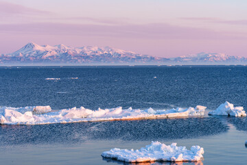 Drift ice and the Shiretoko mountain range with Mount Rausu illuminated by morning light from Notsuke Peninsula, Hokkaido, Japan © ibuki