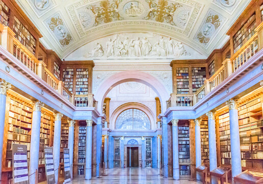 The magnificent neoclassical interior of the historic Pannonhalma Archabbey Library with ancient books and ceiling paintings, a UNESCO World Heritage Site.