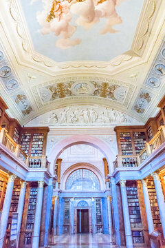The magnificent neoclassical interior of the historic Pannonhalma Archabbey Library with ancient books and ceiling paintings, a UNESCO World Heritage Site.