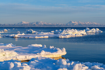 Drift ice and the Shiretoko mountain range with Mount Rausu illuminated by morning light from Notsuke Peninsula, Hokkaido, Japan © ibuki