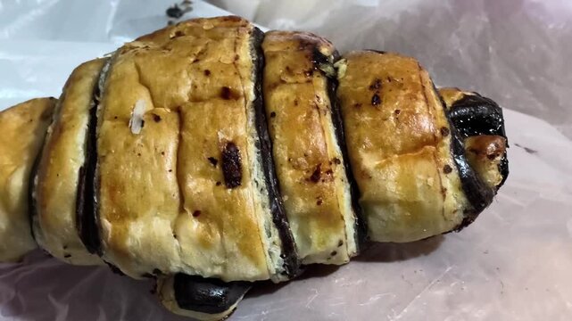 Freshly Baked Chocolate Croissant Pastry on White Plastic Wrapper