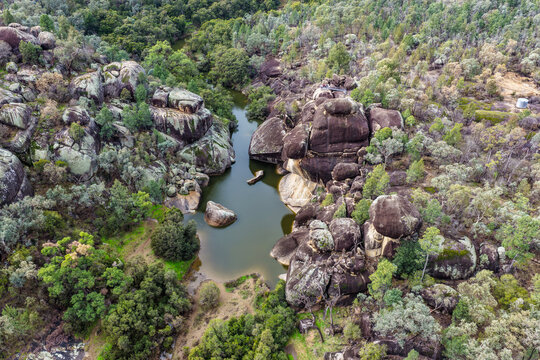 Aerial view of Reedy Creek winding through the granite rock formations and lush green bushland of Cranky Rock Nature Reserve near Warialda, NSW. The scenic landscape highlights the natural beauty