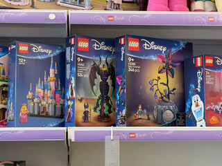 Fototapeta premium Toy store shelf with colorful lego disney boxes on display