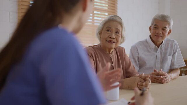 Health insurance with caregiver at home Senior woman man doctor consultation healthcare clinic happy elderly couple medical advice support with caregiver during bright calm appointment table near