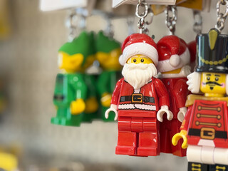 Fototapeta premium Close-up of hanging toy Santa and nutcracker keychains with a blurred background, showing bright christmas colors and a festive holiday mood.