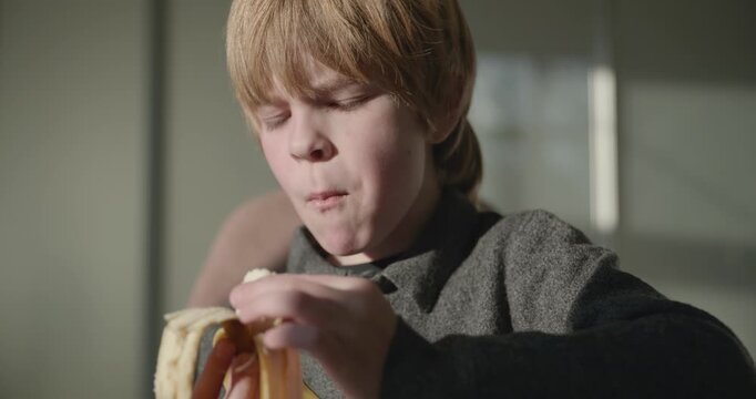 Kid Boy Eat Banana Fruit. Eating Breakfast Lunch in Kitchen. 4K 10-bit