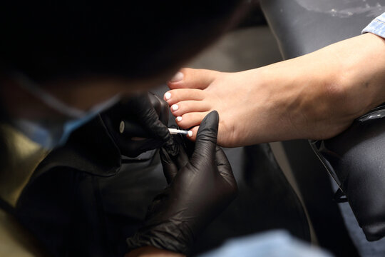 A woman's feet during a pedicure. Woman getting pedicure in beauty salon, closeup. A pedicurist working at a beauty salon. Manicure services. Nail art. Beauty salon concept: pedicures.