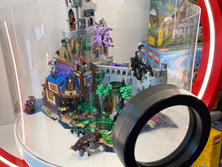 Fototapeta premium Fantasy lego castle display in a glass case with a magnifying glass, showing a detailed miniature toy scene