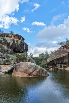 Aerial view of the natural rock pool, elevated viewing platform and striking granite rock formations at Cranky Rock Nature Reserve near Warialda, NSW. Carved by Reedy Creek and surrounded by bushland