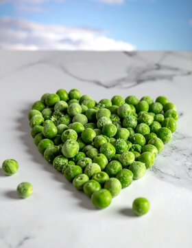 A heart-shaped arrangement of vibrant green peas on a marble surface
