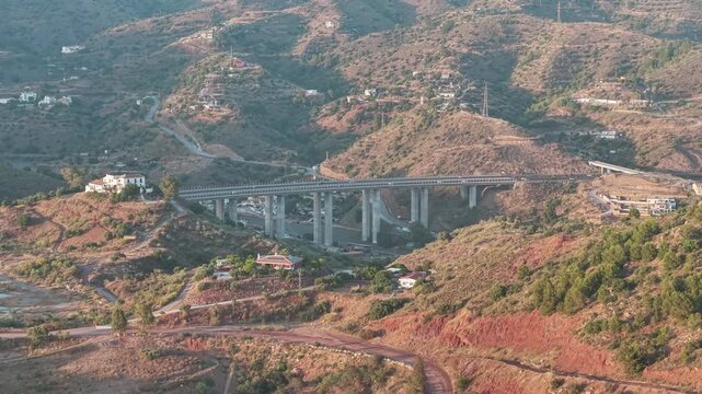 Aerial forward view of a bridge in a dry arid area. Malaga, Spain.