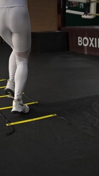 A Caucasian woman trains on a gait ladder. Close-up of her legs.