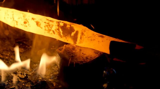The blacksmith employs a powerful mechanical hammer to shape glowing metal on an anvil, followed by intense reheating within a coal fire furnace for further industrial forging operations.