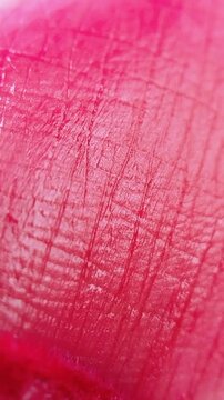 Extreme close up of lip skin being applied with pink lip tint using a cosmetic brush. Soft pigment application, beauty makeup concept for lip care product.