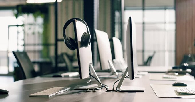 Office, equipment and computer with headset in call center agency for virtual assistance. Empty, space and technology with lens flare or help desk for business operations or startup in workplace