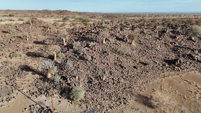 Cinematic aerial footage flying over extremely rugged and barren rocky desert terrain in Namibia, Africa. A harsh, ancient geological landscape.