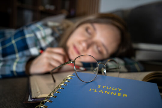Exhausted, sleeping and student on desk in classroom at school with fatigue in lesson for learning. Burnout, relaxing and girl teenager with nap for narcolepsy with education or studying for exam.