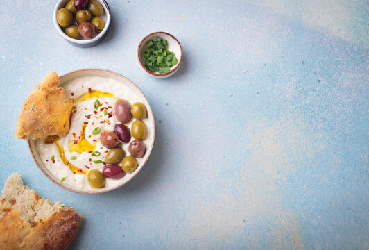 Labneh yogurt dip with olives and pita bread Middle Eastern meze top view copy space