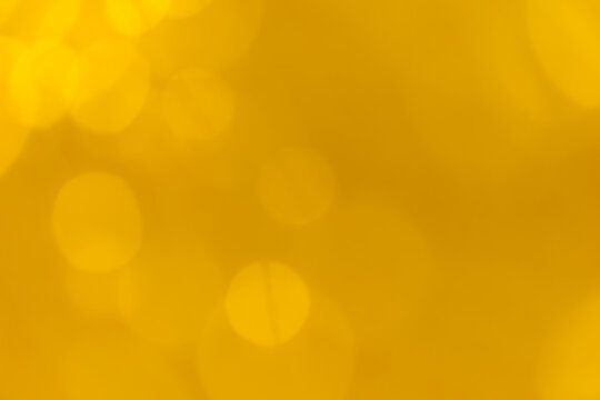 Abstract warm golden bokeh lights background with soft yellow glow