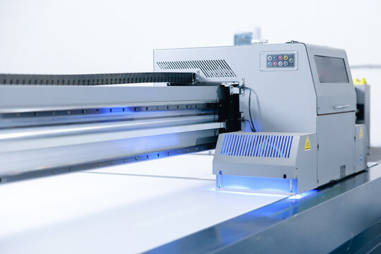 Commercial flatbed UV printing machine with control panel and illuminated head for large format production