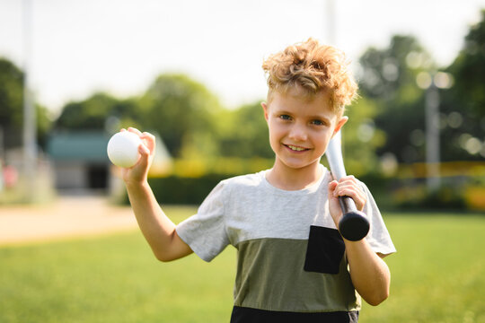 Young boy play baseball on a field in summer season