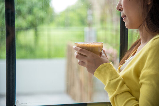 Asian Woman drink black coffee hand holding cup at cafe garden. Young woman smile face love drink coffee. Women lifestyle Cafe. Active woman drinking black tea cup in coffee shop holding fresh mug