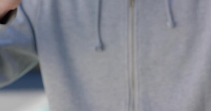 African American man gray hoodie hovering picking up and donning headset from green mat, listening