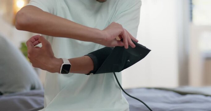 African American man preparing adjusting blood pressure cuff and holding monitor on bed for health