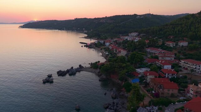 Aerial view of Loutra beach hotels, restaurants, holiday home apartments surrounded by pine forest at sunset, Agia Paraskevi Pine Forest at sunset, Kassandra Peninsula