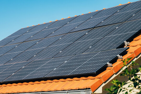 Photovoltaic panels installed on a residential roof, harnessing sunlight to produce sustainable, renewable electricity for homes