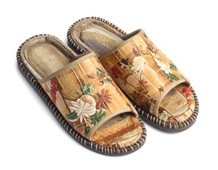 Naklejka premium Pair of decorative fabric slippers with floral patterns isolated on white background